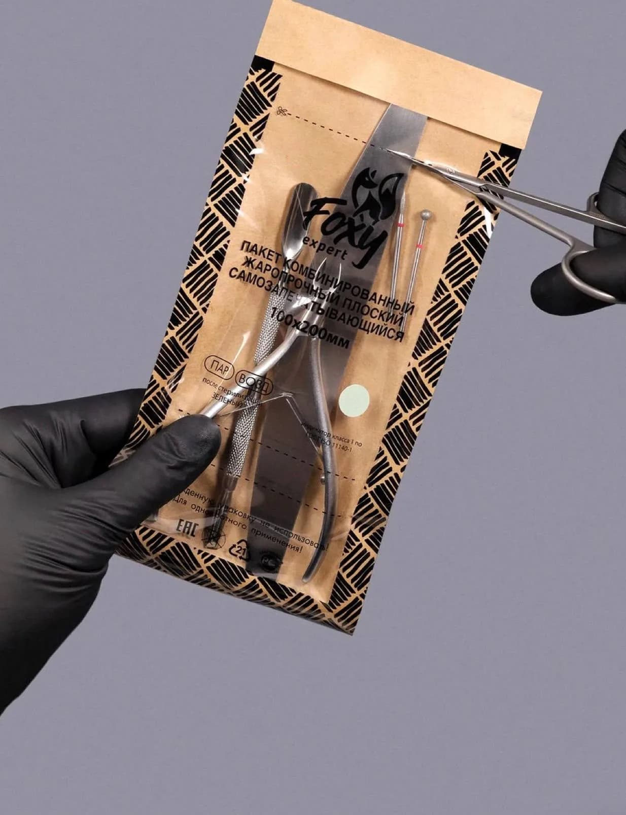 Instrumento esterilizado en su bolsa, abierto con guantes
